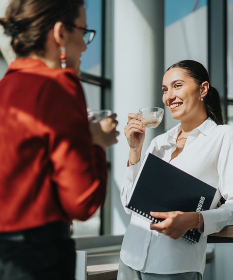 Zwei Kolleginnen trinken Kaffee miteinander