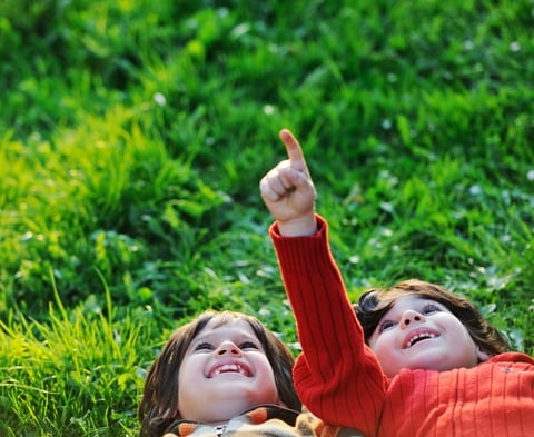 Happy kid enjoying sunny late summer and autumn day in nature on green grass